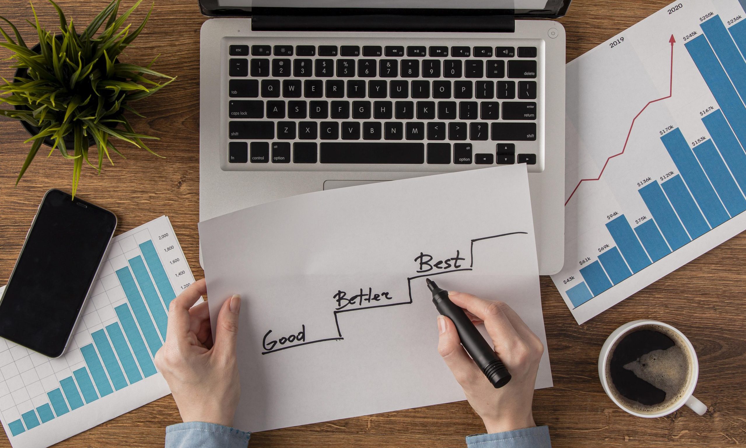 top-view-office-desk-with-growth-chart-held-by-hands
